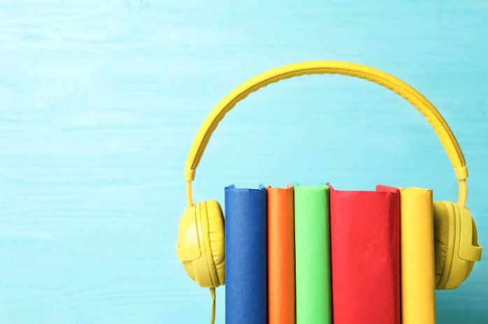 Livres et écouteurs modernes sur fond en bois bleu clair, gros plan.